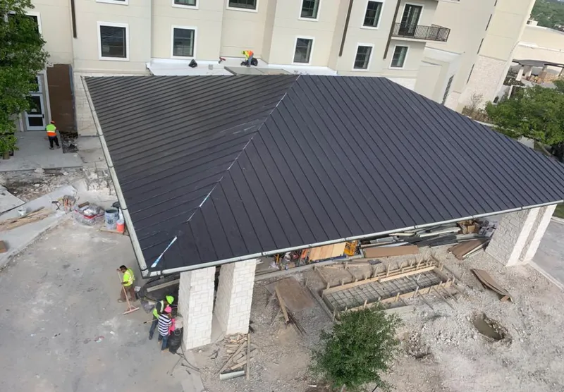 Metal roofing installation team working on a commercial building in Beloit